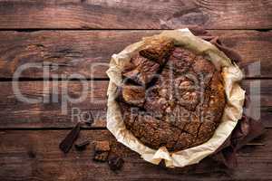 homemade chocolate brownie on dark wooden background, top view