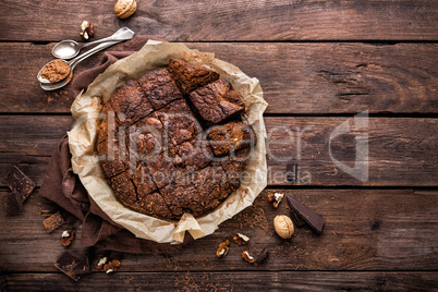 homemade chocolate brownie on dark wooden background, top view