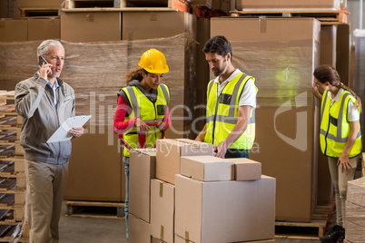 Warehouse manager and workers preparing a shipment