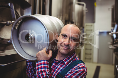 Male manufacturer carrying keg