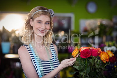 Female florist touching rose flowers