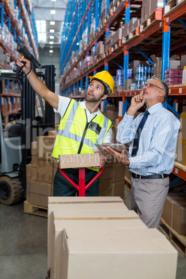 Warehouse manager interacting with male worker