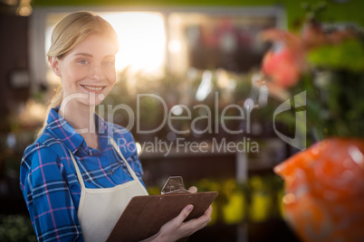 Female florist standing with clipboard