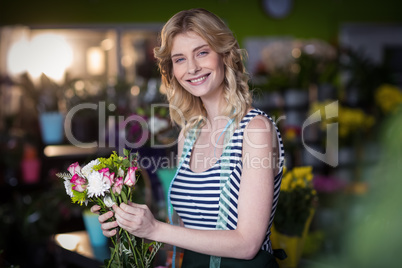 Female florist holding bunch of flowers