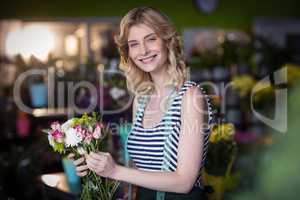 Female florist holding bunch of flowers