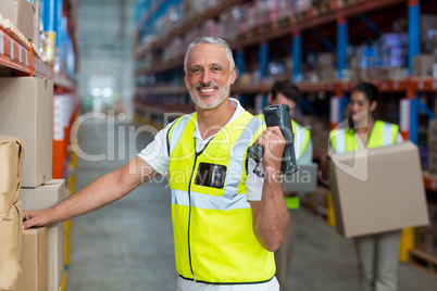 Portrait of smiling warehouse worker scanning box