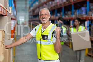 Portrait of smiling warehouse worker scanning box