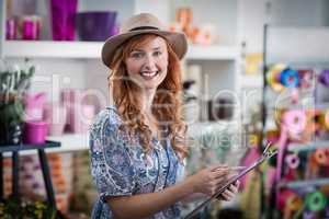 Smiling female florist noting on clipboard