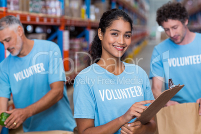 Portrait of smiling volunteer holding clipboard