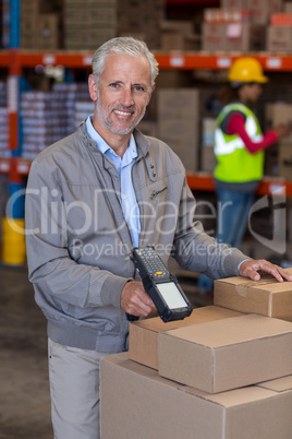 Portrait of warehouse manager scanning the boxes