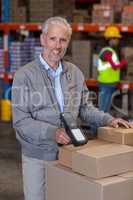 Portrait of warehouse manager scanning the boxes