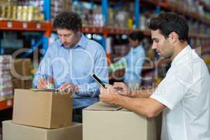Two warehouse workers working together