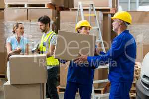 Delivery worker unloading cardboard boxes from pallet jack