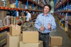 Portrait of warehouse worker showing his thumbs up