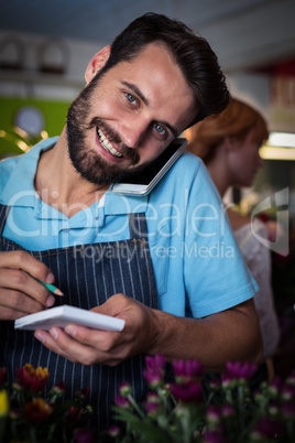Male florist taking order on mobile phone Male florist taking order on mobile phone
