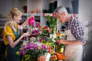 Female florist watering flowers