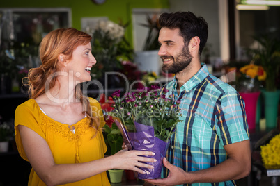 Female florist giving bouquet of flower to man