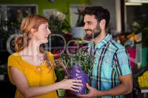 Female florist giving bouquet of flower to man