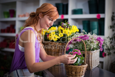 Female florist preparing basket of flowers