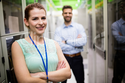 Technicians standing with arms crossed in a server room