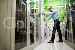 Technician adjusting server cabinet