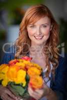 Portrait of female florist holding bunch of flowers