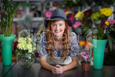 Happy female florist leaning in flower shop