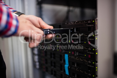 Technician inserting a hard disk drive into a blade server