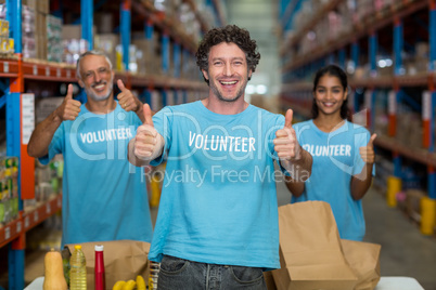 Portrait of volunteers showing thumbs up