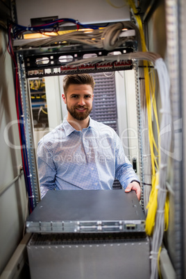 Technician removing server from rack mounted server