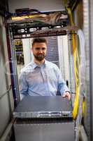 Technician removing server from rack mounted server