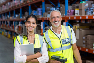 Portrait of warehouse workers standing with digital tablet and barcode scanner