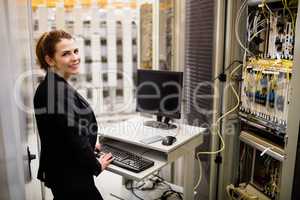 Technician working on computer while analyzing server