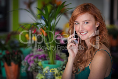Female florist talking on mobile phone in flower shop