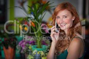 Female florist talking on mobile phone in flower shop