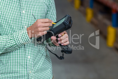 Mid section of worker using hand held computer