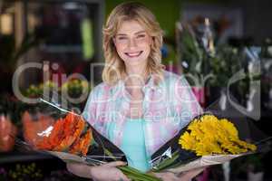 Happy female florist holding flower bouquet