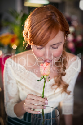 Female florist smelling a rose flower