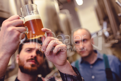 Owner inspecting beer in mug