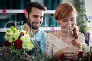Happy couple arranging flowers