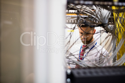 Technician checking cables in a rack mounted server