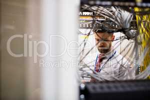 Technician checking cables in a rack mounted server