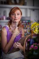 Portrait of female florist holding clipboard