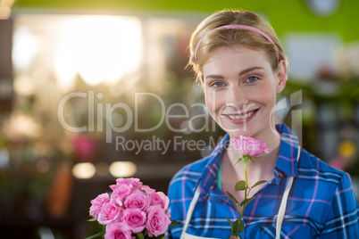 Female florist holding bunch of flower in flower shop