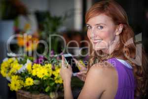 Portrait of female florist using mobile phone