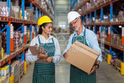Warehouse workers checking cardboard box