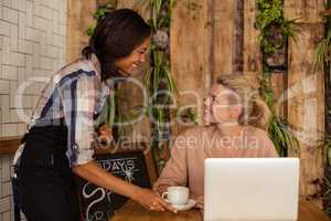 Waitress serving a cup of coffee to customer