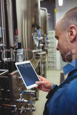 Male owner using digital tablet at brewery