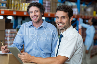 Portrait of warehouse workers using digital tablet