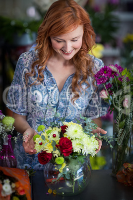 Female florist checking a flowers arrangement in vase
